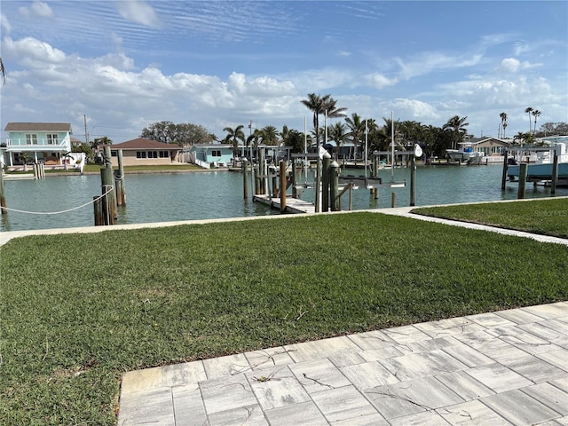 dock area with a water view, boat lift, a residential view, and a yard