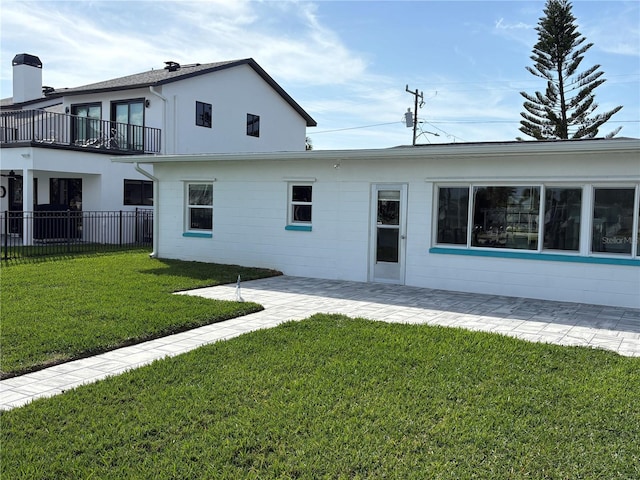 back of property with a yard, a patio area, and fence