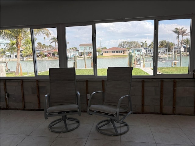 sunroom featuring a water view and a residential view