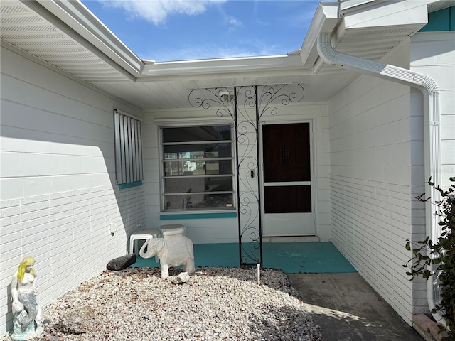 property entrance featuring brick siding