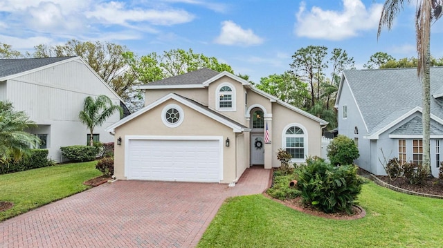 view of front of home featuring an attached garage, stucco siding, decorative driveway, and a front yard