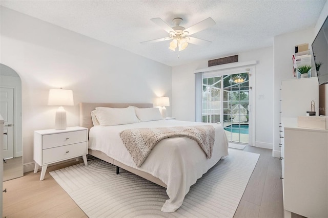 bedroom with a textured ceiling, ceiling fan, baseboards, access to exterior, and light wood-type flooring