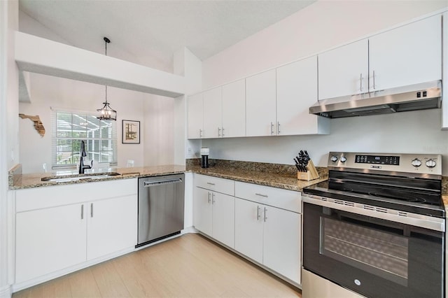 kitchen with appliances with stainless steel finishes, white cabinetry, a sink, and under cabinet range hood