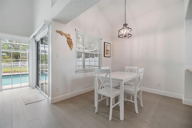 dining space featuring a healthy amount of sunlight, light wood finished floors, and vaulted ceiling