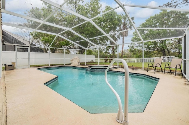 view of pool with a patio, a fenced backyard, a pool with connected hot tub, and a lanai