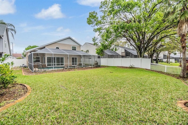 rear view of property featuring a fenced in pool, glass enclosure, a fenced backyard, and a yard