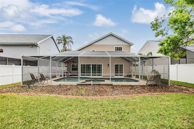 back of property with a fenced in pool, glass enclosure, a fenced backyard, and a yard