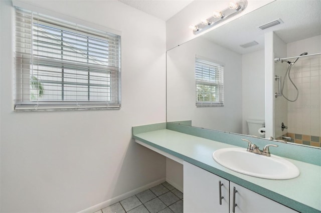 bathroom featuring a textured ceiling, toilet, visible vents, vanity, and tile patterned floors