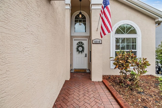 entrance to property featuring stucco siding