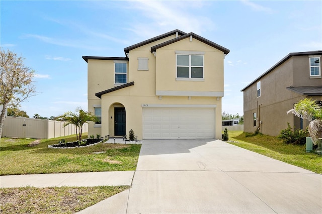 view of front facade with a garage, concrete driveway, stucco siding, fence, and a front yard