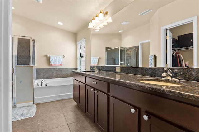 bathroom featuring tile patterned flooring, a sink, visible vents, a spacious closet, and a shower stall