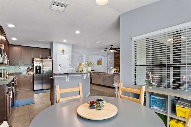 dining area with arched walkways, light tile patterned floors, recessed lighting, visible vents, and a ceiling fan