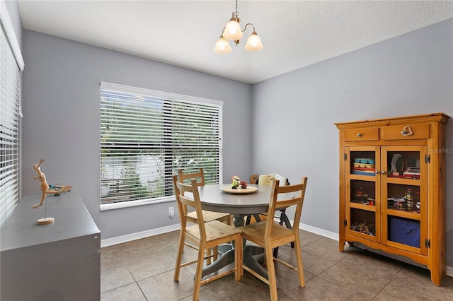 dining area featuring light tile patterned floors, an inviting chandelier, a wealth of natural light, and baseboards