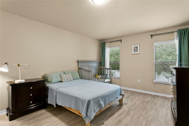 bedroom featuring light wood-style flooring and baseboards