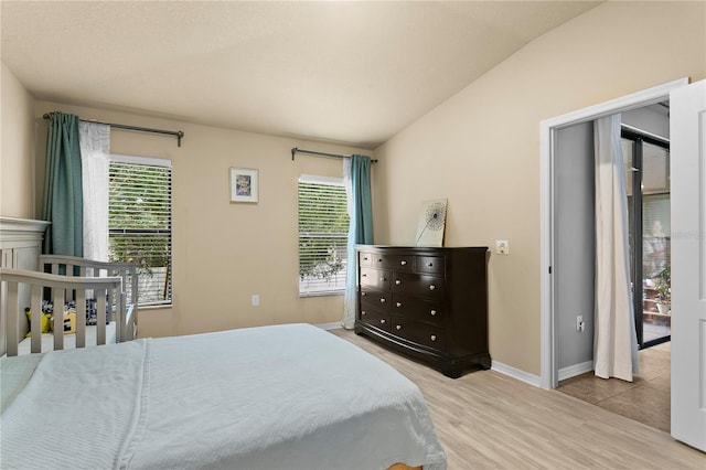 bedroom featuring multiple windows, wood finished floors, and baseboards