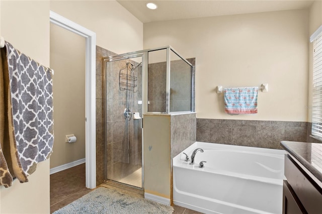 bathroom featuring tile patterned flooring, a garden tub, a shower stall, and vanity