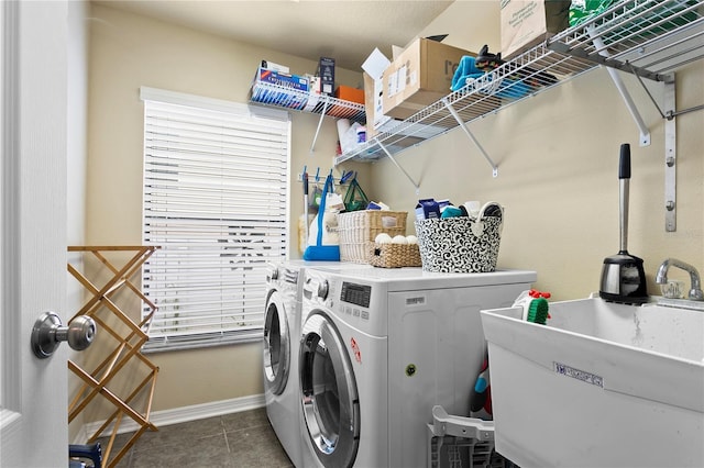 clothes washing area featuring a sink, washer and dryer, laundry area, baseboards, and tile patterned floors