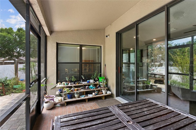 sunroom featuring lofted ceiling and a healthy amount of sunlight