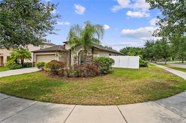 view of property exterior featuring a lawn, an attached garage, fence, stone siding, and driveway