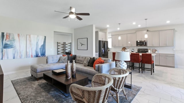 living area featuring baseboards, marble finish floor, ceiling fan, and recessed lighting