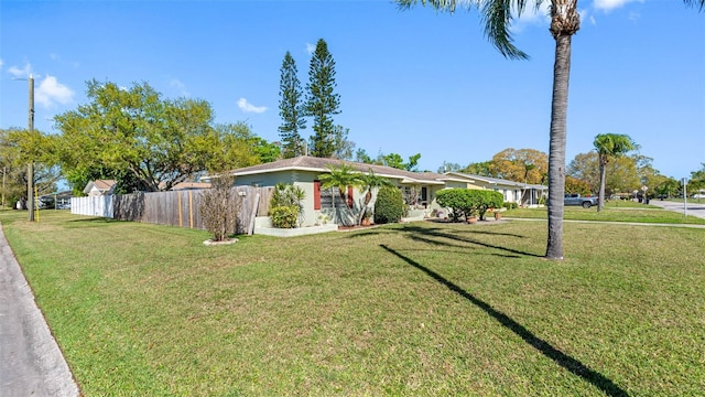 view of front of house with a front yard and fence