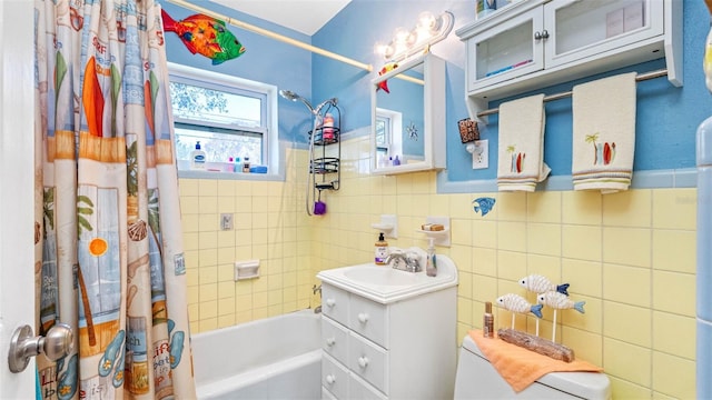 bathroom featuring shower / bath combo with shower curtain, tile walls, and vanity