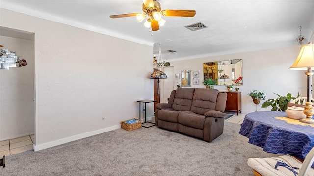 carpeted living area with ceiling fan, tile patterned flooring, visible vents, and baseboards