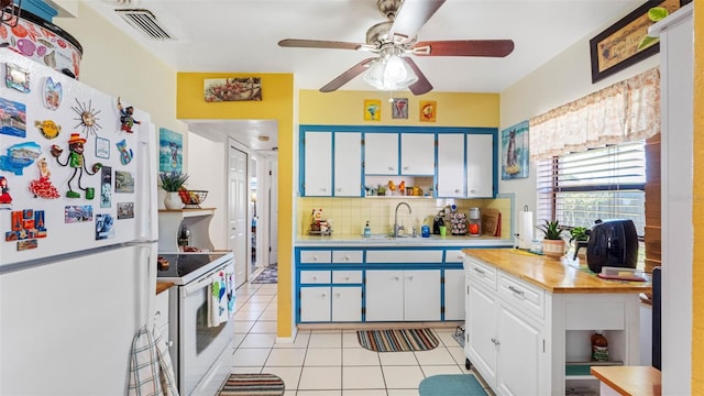 kitchen featuring white appliances, light tile patterned floors, open shelves, and a sink