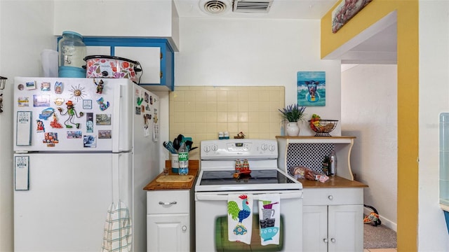 kitchen featuring white appliances, white cabinets, visible vents, and decorative backsplash