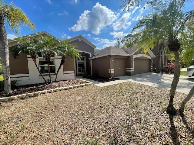 view of front of home featuring an attached garage, driveway, and stucco siding