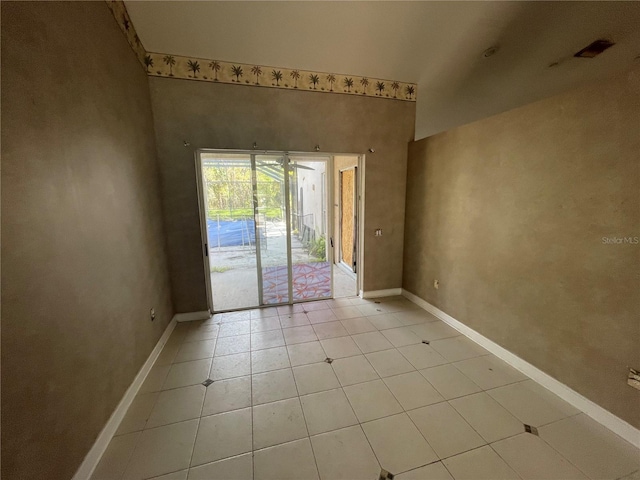 unfurnished room featuring baseboards and light tile patterned flooring