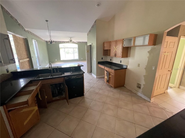 kitchen with dark countertops, black dishwasher, a sink, and light tile patterned floors