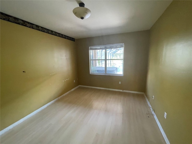 empty room with light wood-type flooring and baseboards