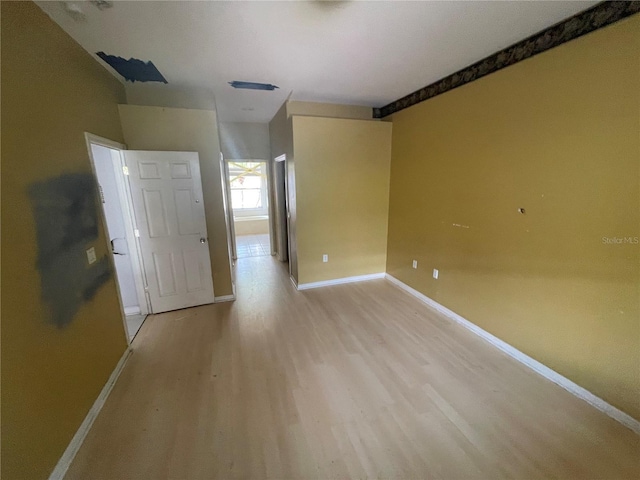 empty room featuring light wood-style floors and baseboards