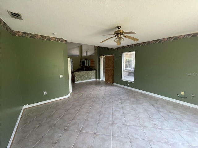 unfurnished living room featuring ceiling fan, visible vents, and baseboards