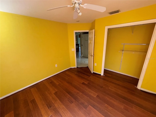 unfurnished bedroom with visible vents, baseboards, a ceiling fan, wood finished floors, and a closet