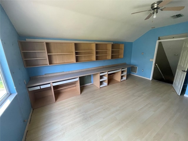 unfurnished office featuring light wood-style floors, visible vents, and vaulted ceiling