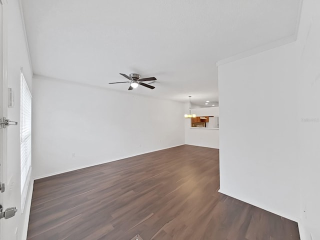 unfurnished living room featuring ceiling fan with notable chandelier and dark wood-type flooring