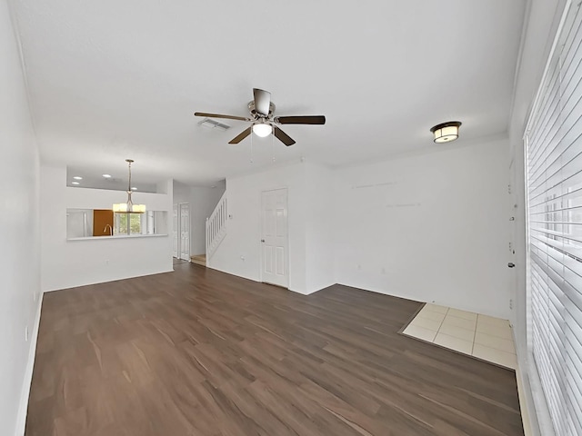 unfurnished living room with dark wood-style floors, ceiling fan, and stairway