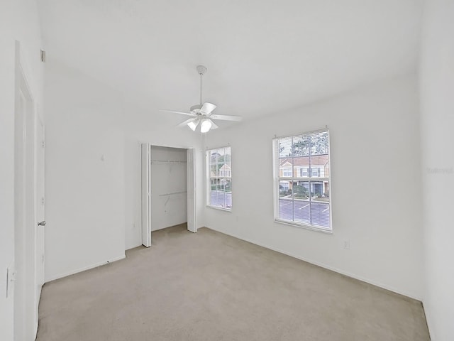 unfurnished bedroom with a ceiling fan, a closet, and light colored carpet