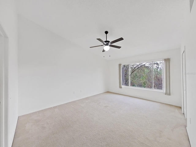 empty room featuring a ceiling fan and light colored carpet