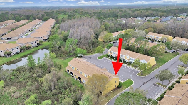 birds eye view of property with a water view, a residential view, and a view of trees