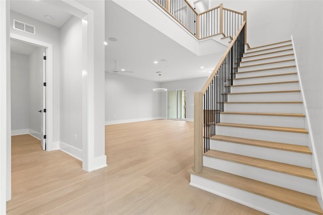 stairs with baseboards, visible vents, wood finished floors, and recessed lighting