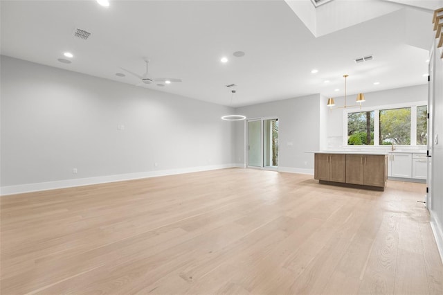 empty room featuring baseboards, light wood-style flooring, visible vents, and recessed lighting