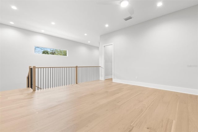 empty room featuring baseboards, light wood-type flooring, visible vents, and recessed lighting