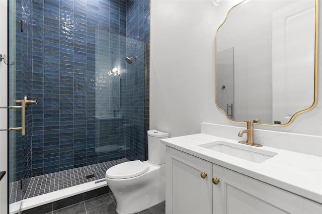 bathroom featuring vanity, a tile shower, and toilet