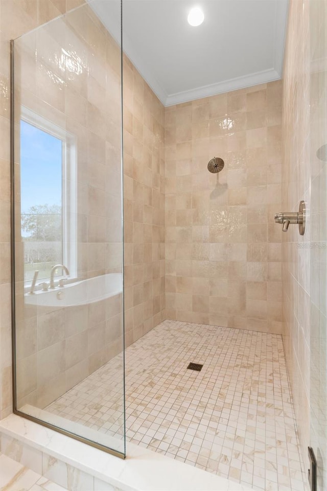 bathroom with tiled shower and crown molding