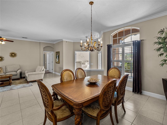 dining room with ornamental molding, arched walkways, baseboards, and light tile patterned floors