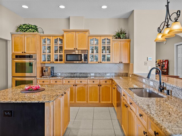 kitchen with backsplash, light tile patterned floors, stainless steel appliances, and a sink