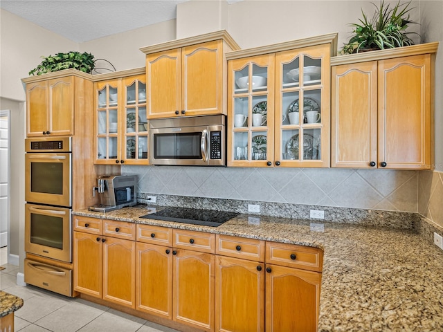 kitchen with light tile patterned floors, tasteful backsplash, stainless steel appliances, and a warming drawer